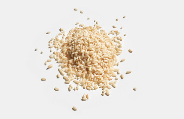 Pile of uncooked brown rice isolated on white background for cooking and food ingredients.