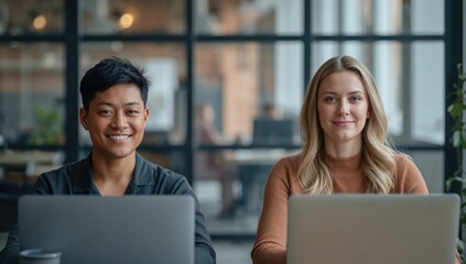 Modern coworking space with natural light featuring two focused diverse professionals