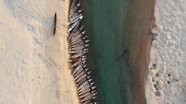 Jaflong, Bangladesh - 21 August 2025: Aerial view of numerous boats contrasting against the light sandy shore and the turquoise water of the river.