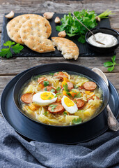 Polish sauerkraut soup with sausage in a bowl