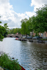 Fototapeta premium A cityscape view over the canal with a bridge in the city of Amsterdam, Netherlands.