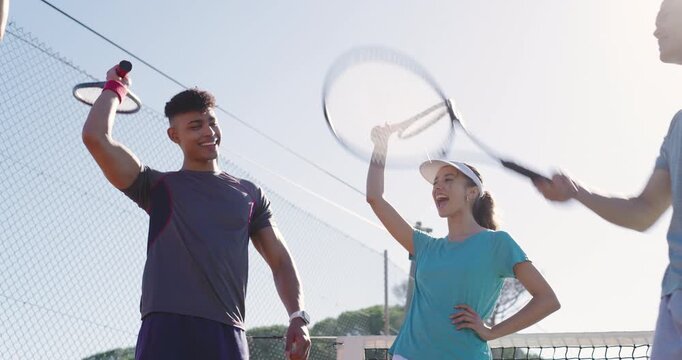 Tapping rackets sparking cheer, Diverse friends on court walking toward bench grabbing water bottle