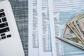 US Tax Form 1040 with Money, Pen and Laptop &ndash; Individual Income Tax Filing and Finance