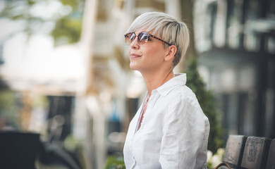 Side view of gorgeous woman with blond short hair wearing sunglasses. Profile of female person...