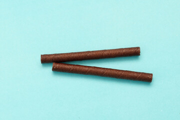 Wafer Roll filled with delicious white chocolate on blue background 