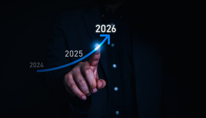 Businessman pointing to a glowing arrow growth graph from 2024 to 2026, symbolizing business development, financial success, and future strategy planning.