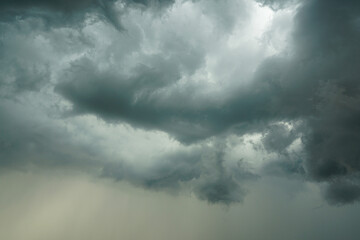 Fototapeta premium Dark storm clouds with heavy rain streaks forming in dramatic sky before a summer thunderstorm