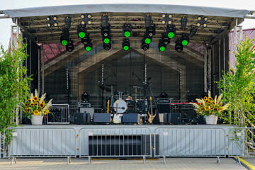 Outdoor concert stage with instruments, lights, and decorations prepared for live performance