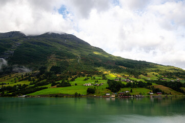 Norway villages in fjord on near olden. Cloudy Nordic day.