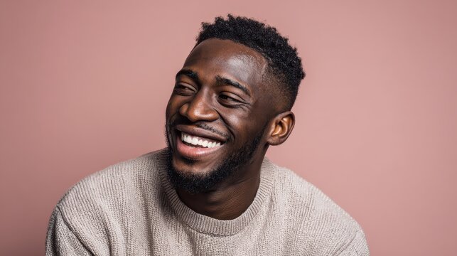 handsome unshaven young darkskinned male laughing out loud at funny meme he found on internet smiling broadly showing his white straight teeth positive human facial expressions and emotions no logos