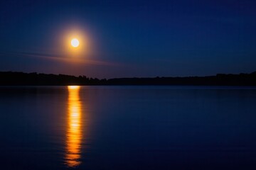 Obraz premium A Serene Reflection of the Moon on a Calm Lake