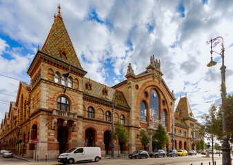 Fototapeta premium Central Market Hall with colorful Zsolnay tiled roof and neo-gothic art nouveau facade under blue sky, a famous landmark and shopping destination in Budapest, Hungary.