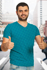 A cheerful man in a city environment confidently giving a thumbs-up sign. Perfect for themes of positivity, encouragement, approval, confidence, success, and urban lifestyle.