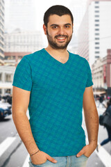 Casually dressed young man standing in a bustling city street, smiling confidently at the camera. Bright urban background with a vibrant, cheerful ambiance reflects positivity and self-assurance.