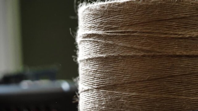 Close-Up Unrolling Jute Twine from Roll with Natural Fiber Texture