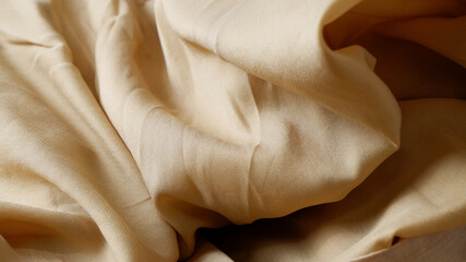 Gold-brown fabric background. Close-up cloth texture background. Concept of earth tone, stylish, silk, classic, luxury, minimal for textiles, cover, wallpaper, fashion. Brown fabric surface.