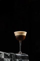 Classic espresso martini alcoholic cocktail with coffee at the dark atmosphere of the bar