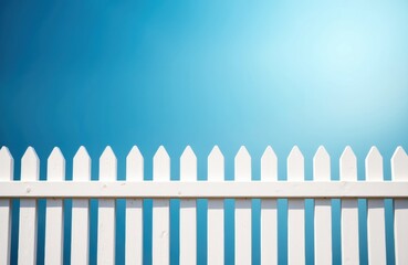 A white picket fence set against a bright blue sky with a gradient effect