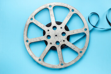 Old 35mm motion picture film reel on blue background. Cinema concept