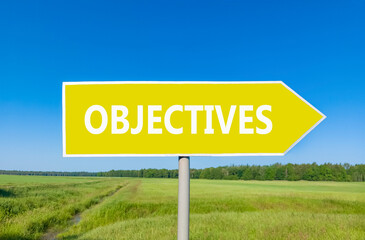 Objectives symbol. Concept word Objectives on beautiful yellow road sign. Beautiful blue sky green grass and forest peaceful nature background. Business objectives concept. Copy space.