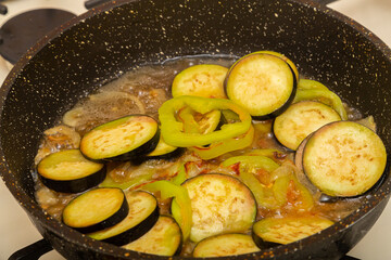 Zucchini cut into rings are fried in a frying pan in oil and spices