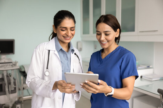 Positive diverse young medical colleagues discussing patient electronic records