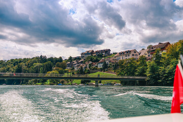 Majestic view of Rhine Falls, the largest waterfall in Europe, located near Schaffhausen in northern Switzerland. Powerful cascades of water rush over rugged rocks, surrounded by lush greenery and mis © Breg