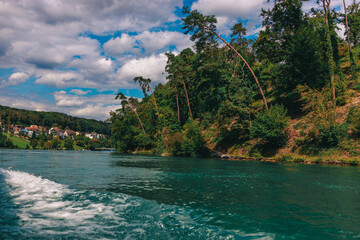 Majestic view of Rhine Falls, the largest waterfall in Europe, located near Schaffhausen in northern Switzerland. Powerful cascades of water rush over rugged rocks, surrounded by lush greenery and mis © Breg