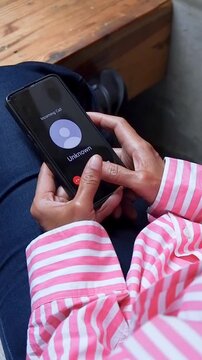 A footage of A woman holding a smartphone receiving an incoming call from an unknown number, showing the screen interface with decline and accept options