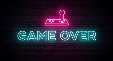 Neon illuminated game over message with joystick symbol on brick wall