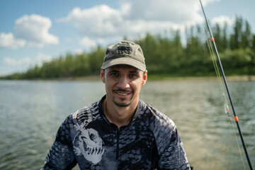 Close-up of fisherman looking at camera against river background