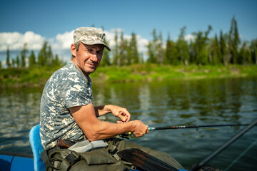 Close-up of an elderly fisherman catching fish with a spinning rod