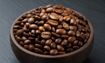 Fototapeta premium Roasted coffee beans piled high in a dark wooden bowl on a dark surface