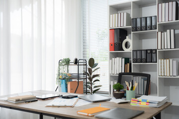 Workspace productivity: The well-organized desk and office space with bright natural light, suggesting focus, efficiency, and a conducive atmosphere for productivity.