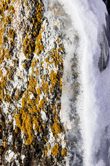 Ice icicles hanging on stone surface of cave, frozen water lake Baikal in winter