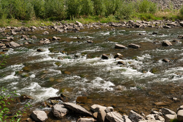 Mountain river. Stones in a turbulent river. Big stones in the mountains