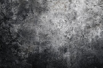 Dark, textured surface with cracks, showing varied shades of grey and black, suggesting age and weathering