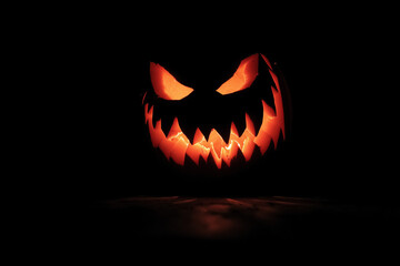 Fototapeta premium Evil Glowing Jack-o’-Lantern in the Dark