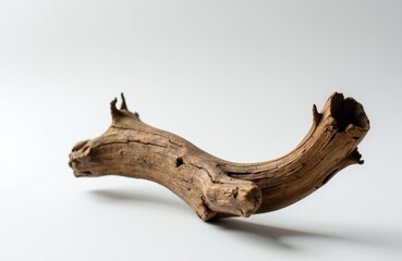 Fototapeta premium A piece of weathered driftwood with a natural, textured surface on a plain white background