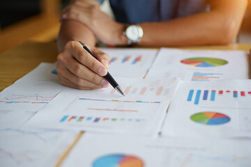 Person analyzing financial reports with charts and graphs