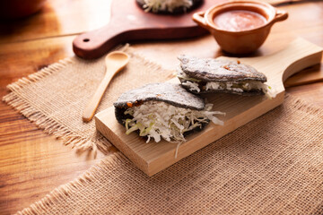Gordita de Chicharron. Blue Cornmeal dough stuffed with chicharron prensado. Traditional Mexican snack commonly accompanied by cilantro, onion and hot sauce.