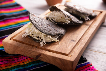 Gordita de Chicharron. Blue Cornmeal dough stuffed with chicharron prensado. Traditional Mexican snack commonly accompanied by cilantro, onion and hot sauce.