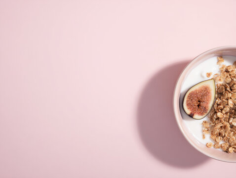 Top view of granola yogurt bowl with figs and berries on pastel pink with negative space.
Great for social media graphics, product labels, or clean food marketing. - Powered by Adobe