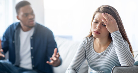 Domestic Conflicts. Young Multicultural Couple Quarrelling In Living Room At Home, Annoyed Black Guy Blaming His Upset White Girlfriend, Interracial Lovers Suffering Relationship Crisis
