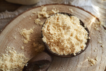Dried whey protein powder on a wooden spoon