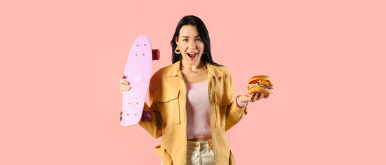 Surprised young woman with tasty burger and skateboard on pink background