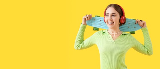 Young woman in headphones, with dental braces and skateboard on yellow background with space for text