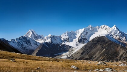 majestic snow capped mountains under a clear blue sky in a tranquil outdoor landscape