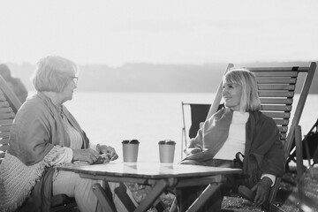 Elderly women enjoying relaxing time together by lake