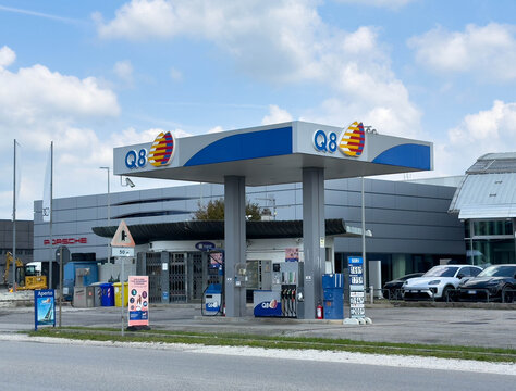 Udine, Italy - August 26, 2025: Q8 gas station located near a luxury car dealership, featuring fuel pumps and a modern architectural design, ideal for automotive and travel themes